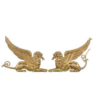 Paire de chenets en bronze doré ornés de lions ailés. France, début du XIXe siècle.