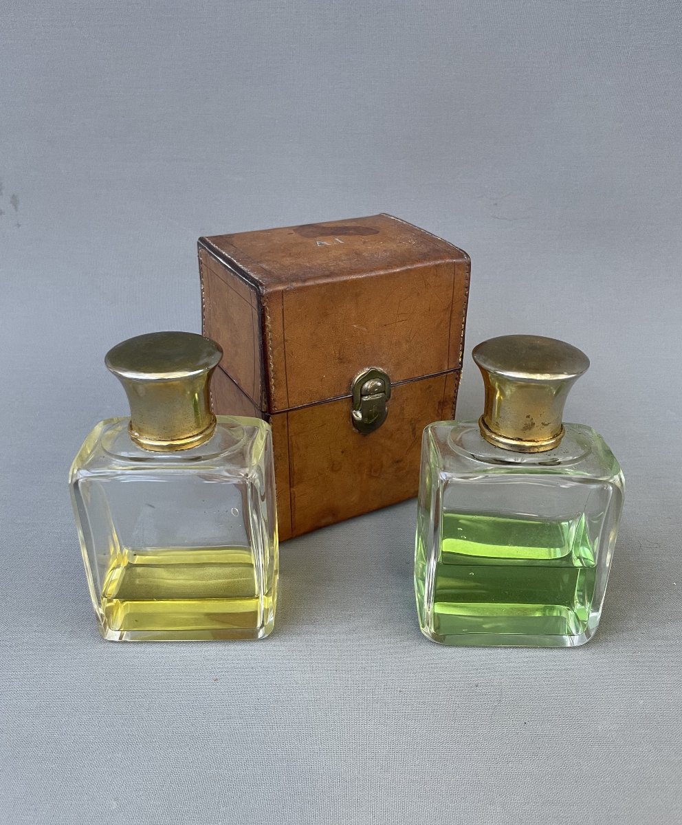 Two Bottles Of Perfume And Their Travel Case