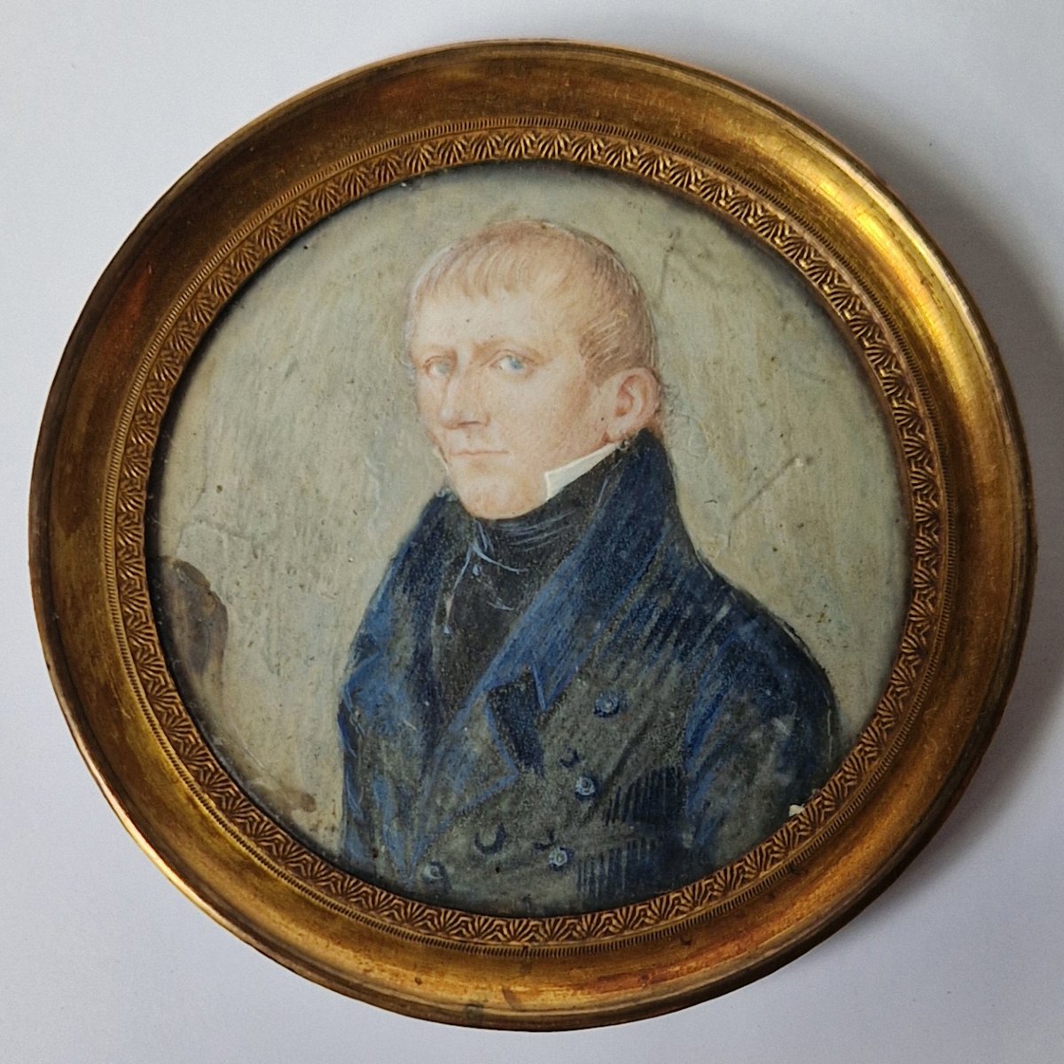 École néerlandaise vers 1820: Portrait en miniature représentant un jeune homme en habit bleu  