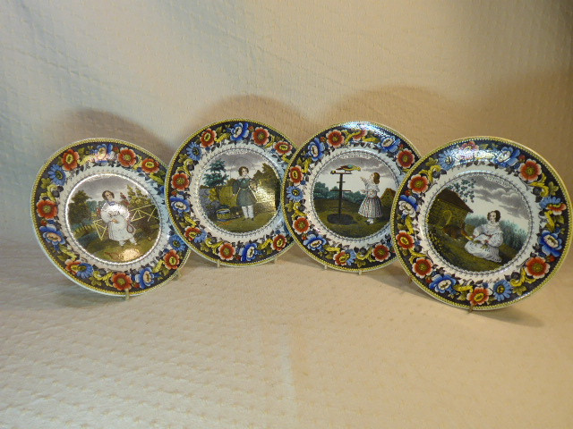 Quatre assiettes polychromes de Creil présentent différentes scènes de jeu d'enfants.