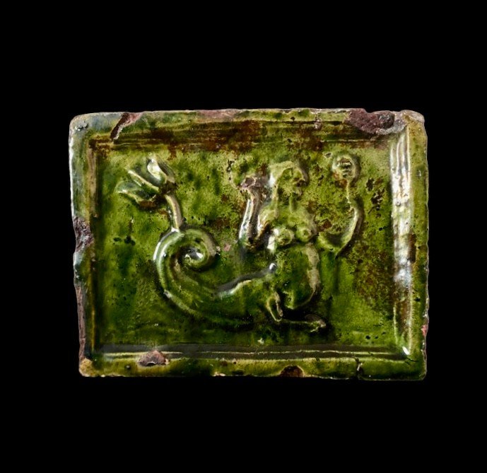 Un Carreau De Poêle En Faïence à Glaçure Verte Avec Une Créature Marine Et Un Miroir, Vers 1600