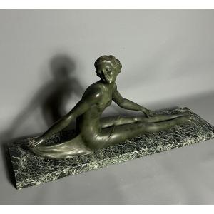 Elégante sculpture en bronze représentant une femme nue assise, dans une posture gracieuse et c